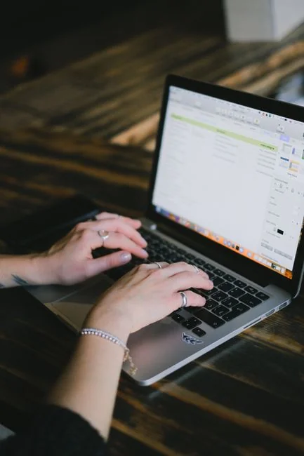 Close-up of a woman working on a digital marketing project in a home office setting.
